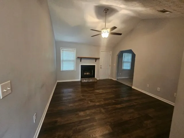 a view of a hallway with wooden floor and a fireplace