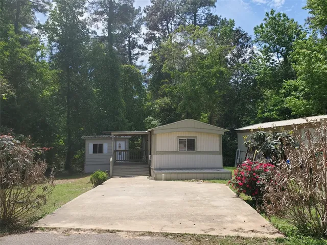 a front view of a house with a garden and flowers