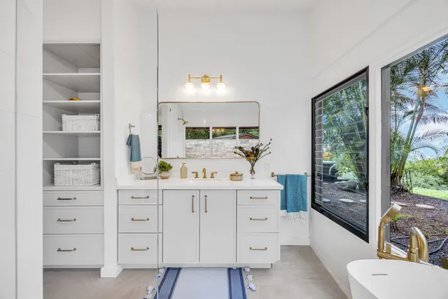 a kitchen with white cabinets and outdoor space