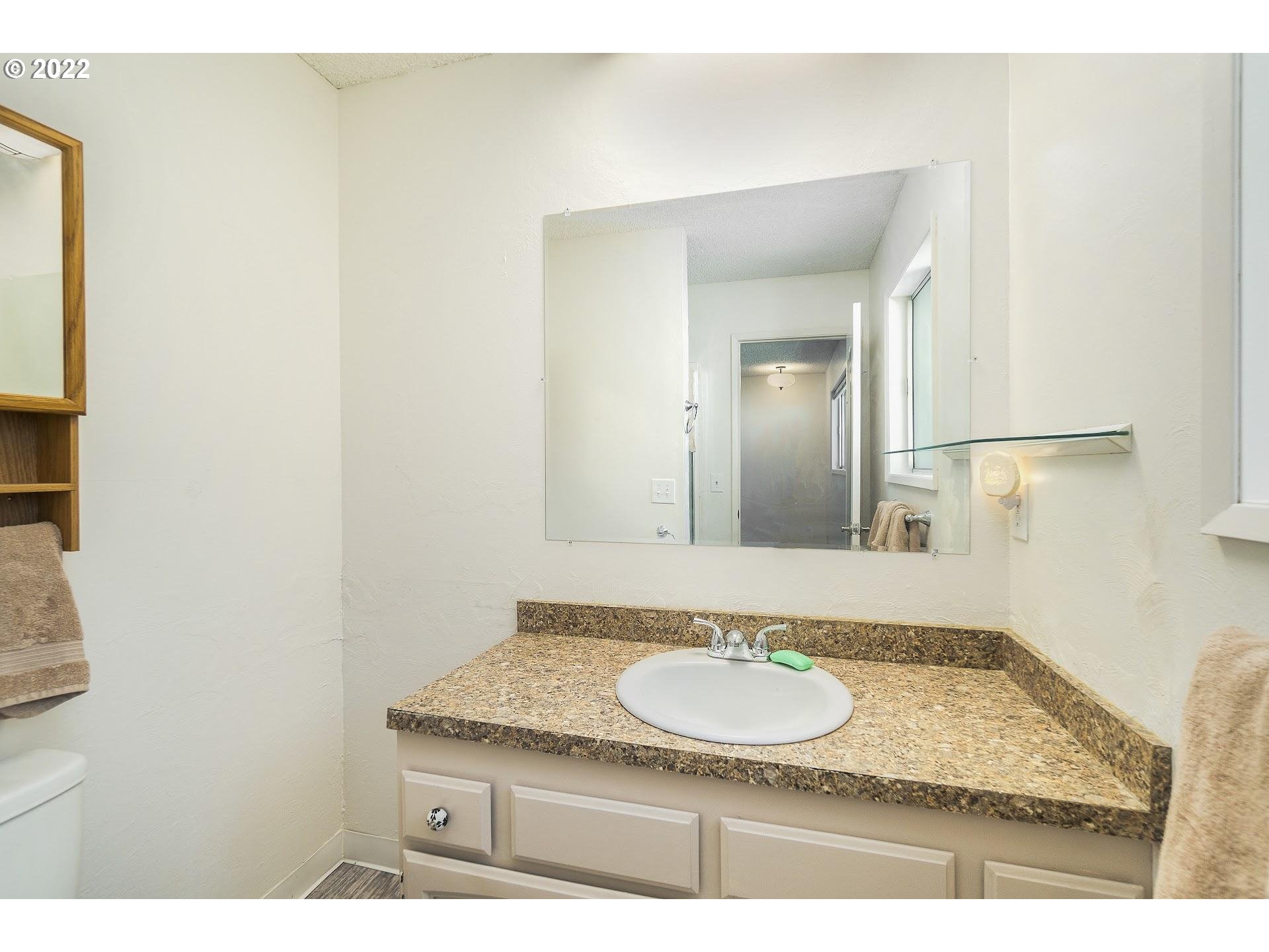 10880 Southwest Pathfinder Way Tigard, OR 97223 - Photo 14 of 26 a bathroom with a granite countertop sink and a mirror
