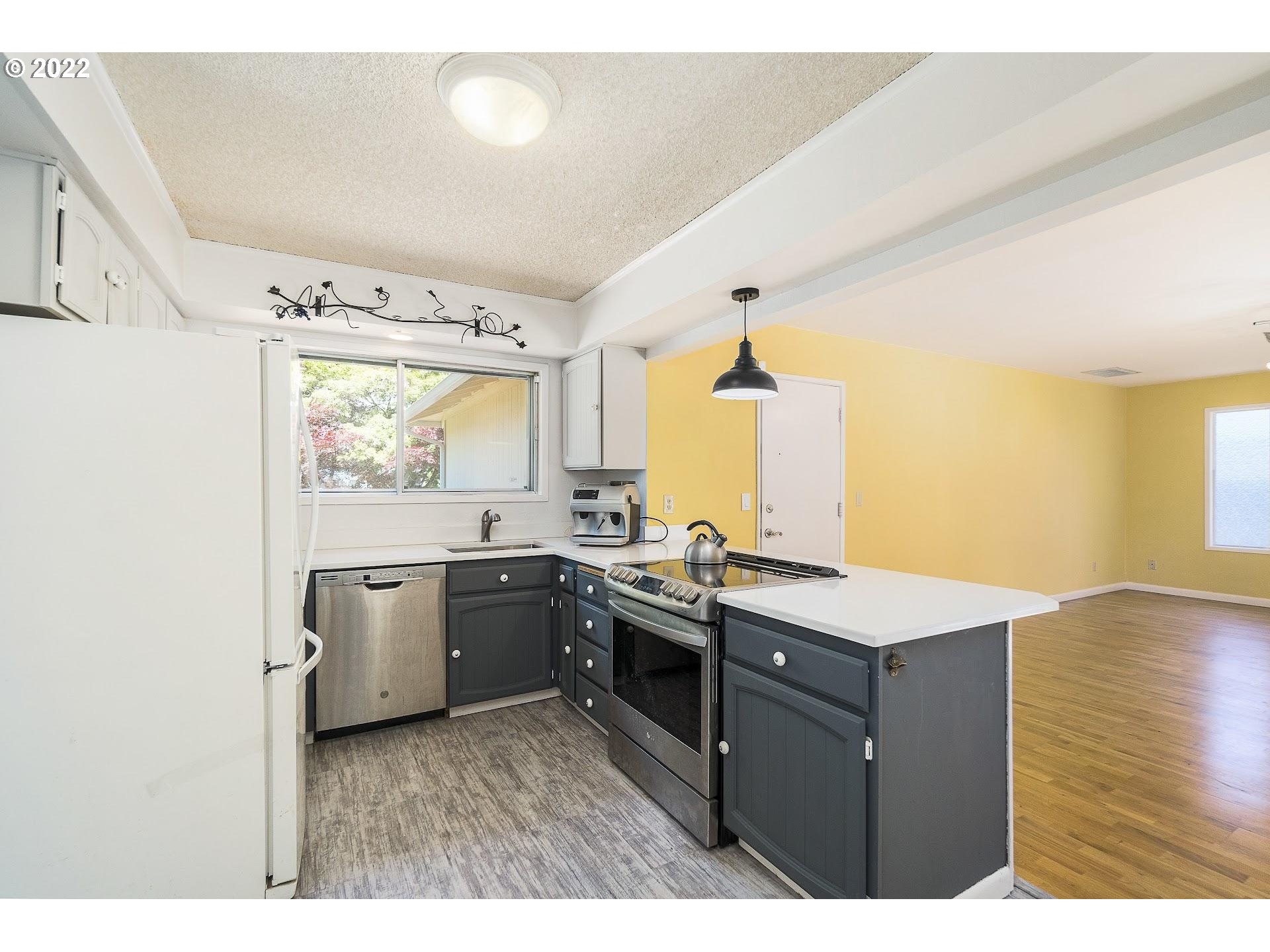 10880 Southwest Pathfinder Way Tigard, OR 97223 - Photo 6 of 26 a kitchen with a stove a sink and a refrigerator