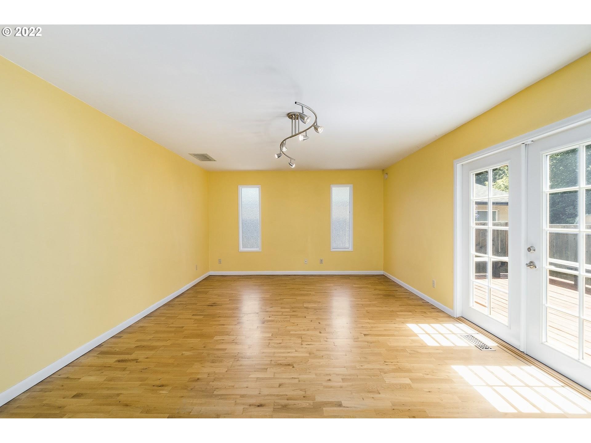 10880 Southwest Pathfinder Way Tigard, OR 97223 - Photo 8 of 26 a view of an empty room with wooden floor and a window