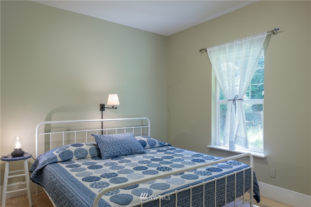 525 Port Stanley Road Lopez Island, WA 98261 - Photo 12 of 28 a bedroom with a bed and wooden floor