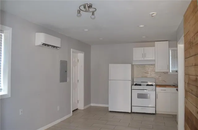 a kitchen with white cabinets and white appliances