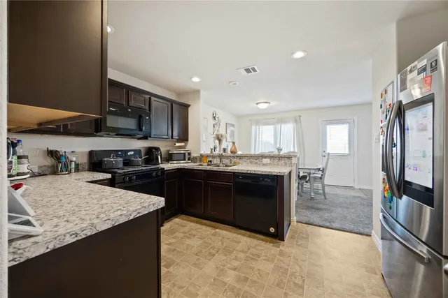 a kitchen with stainless steel appliances granite countertop a stove top oven a sink and dishwasher