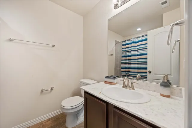 a bathroom with a granite countertop sink toilet and a mirror