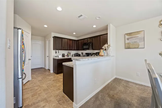 a kitchen with a refrigerator and a stove top oven