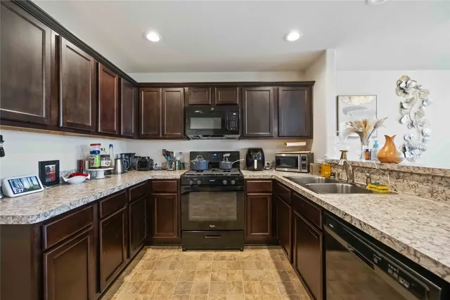 a kitchen with a sink stove top oven and cabinets