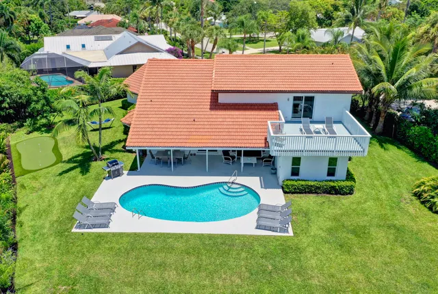an aerial view of a house with swimming pool and garden