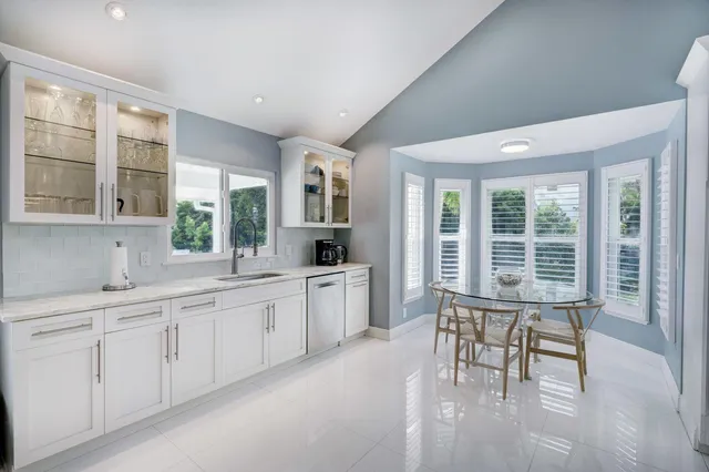 a kitchen with stainless steel appliances granite countertop a kitchen island a stove a table and chairs