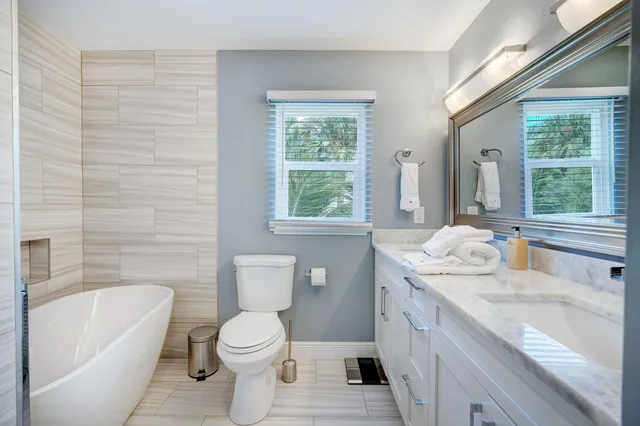 a bathroom with a granite countertop toilet sink and mirror