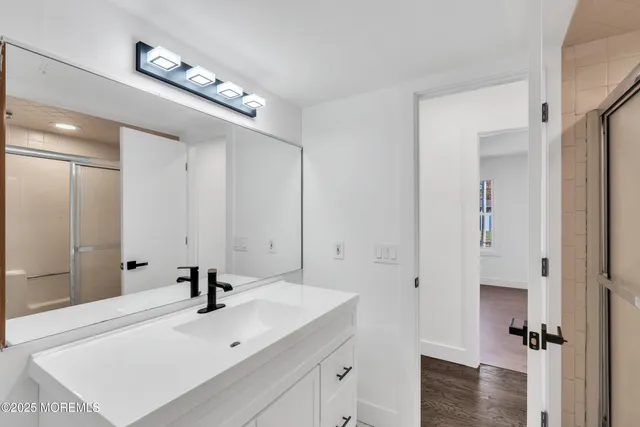 a bathroom with a sink a toilet and shower