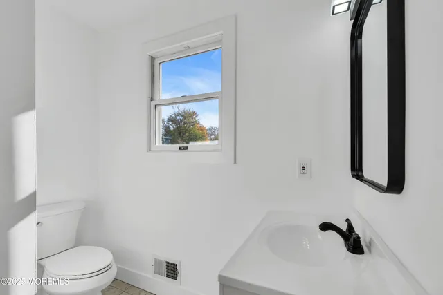 a white toilet sitting next to a bathroom sink
