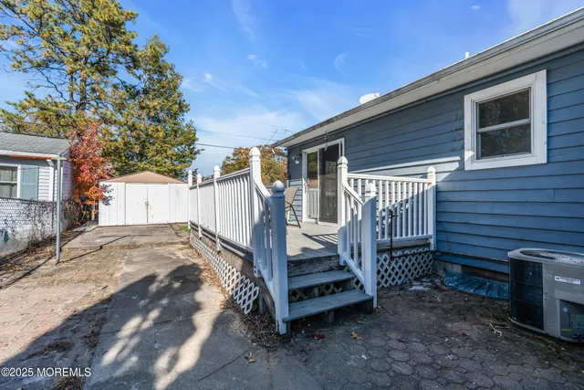 a view of a house with backyard and wooden fence