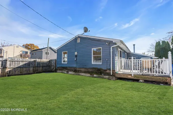 a view of a house with a yard and deck