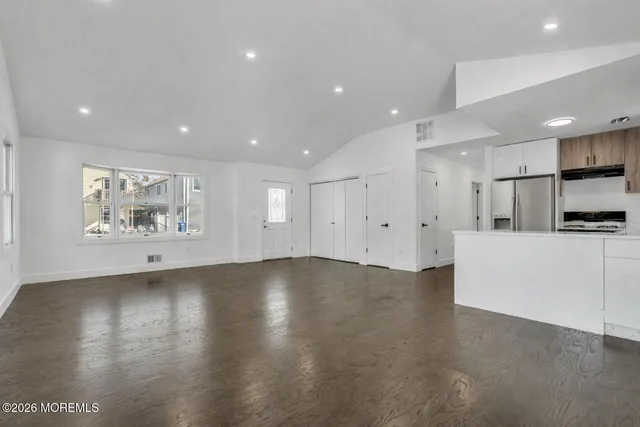 a view of an empty room with a kitchen