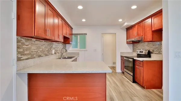 a view of empty room with window and wooden floor