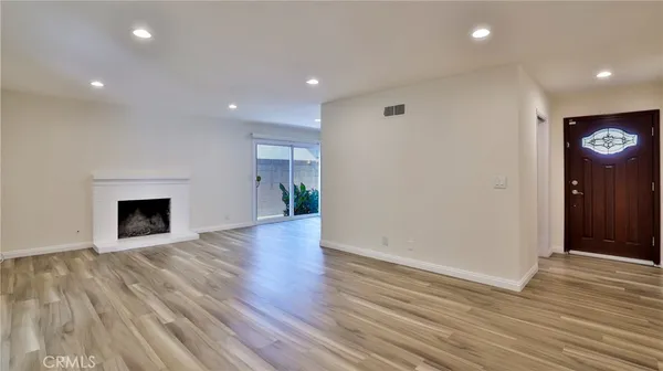 a view of a big room with wooden floor and windows