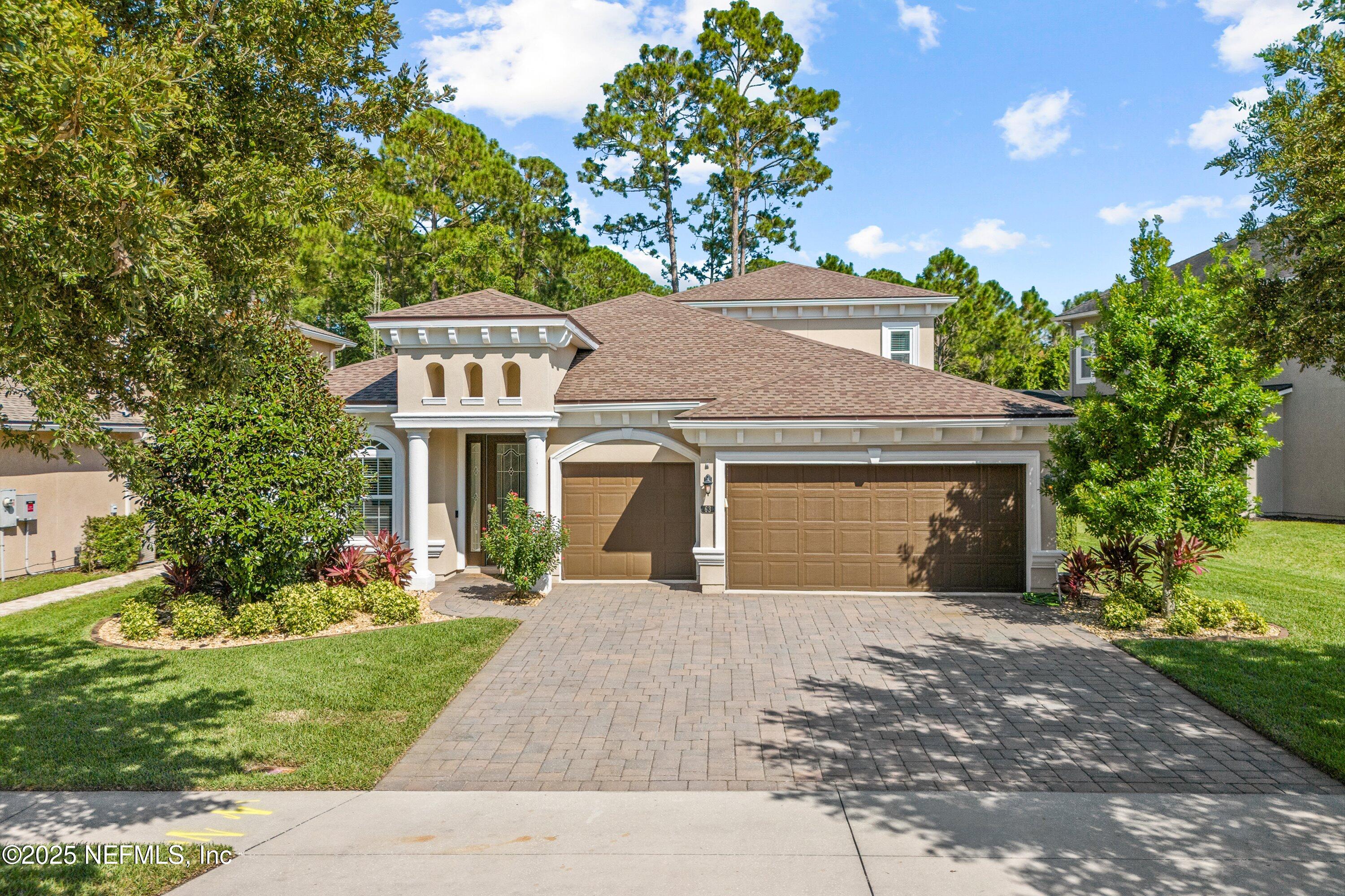 a front view of a house with a yard and trees