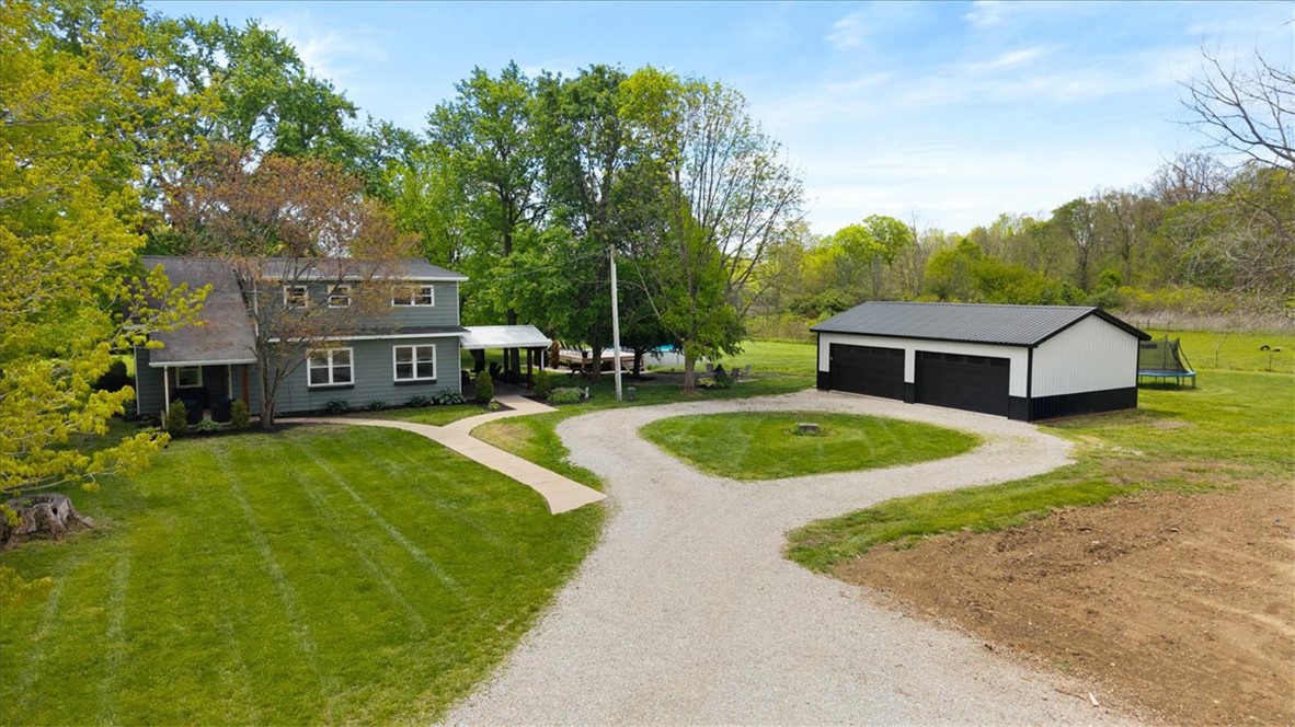 5120 Wheelock Road Troy, OH 45373 - Photo 58 of 67 This expansive property features a charming home, a detached garage, and a lush green landscape with mature trees.