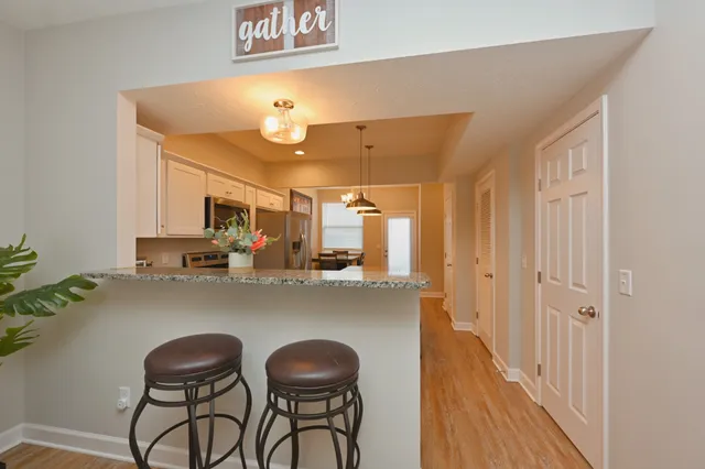 a kitchen with stainless steel appliances a dining table chairs and a refrigerator