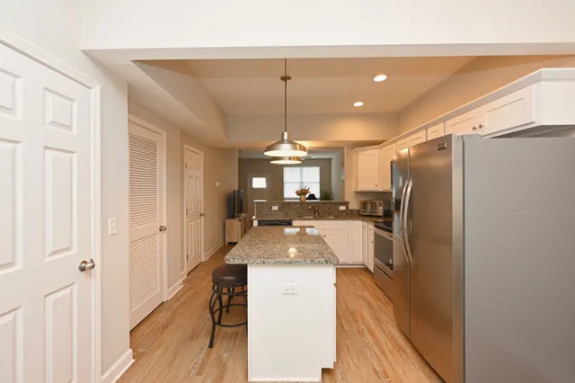 a large kitchen with sink a refrigerator and a stove top oven