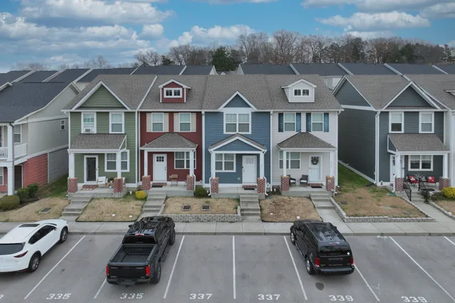 a car parked in front of a brick house with large windows