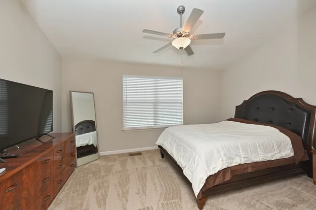 a bedroom with a bed window and a flat screen tv
