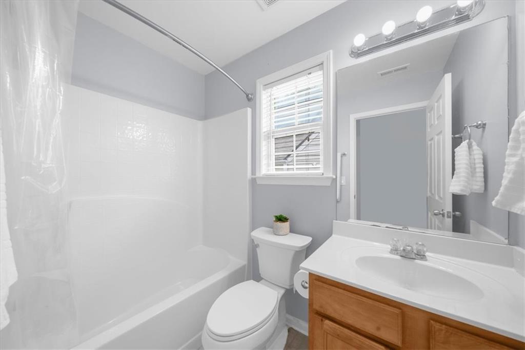 2735 Gateview Court Cumming, GA 30040 - Photo 27 of 35 a bathroom with a sink a toilet a mirror and shower