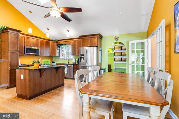 a kitchen with stainless steel appliances granite countertop a refrigerator a stove top oven a sink dishwasher and wooden cabinets