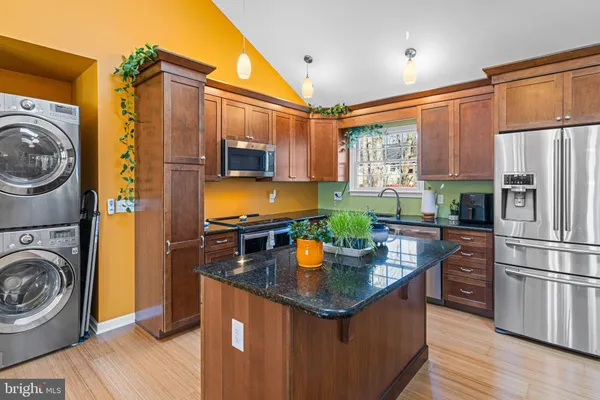 a kitchen with stainless steel appliances granite countertop a sink a stove and refrigerator