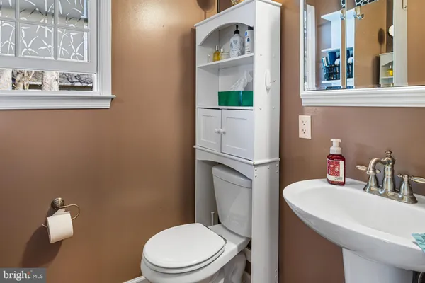 a bathroom with a toilet sink and mirror