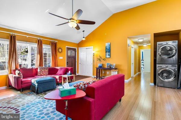 a living room with furniture ceiling fan and a large window