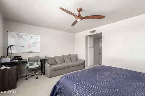 a bedroom with bed cabinet and window