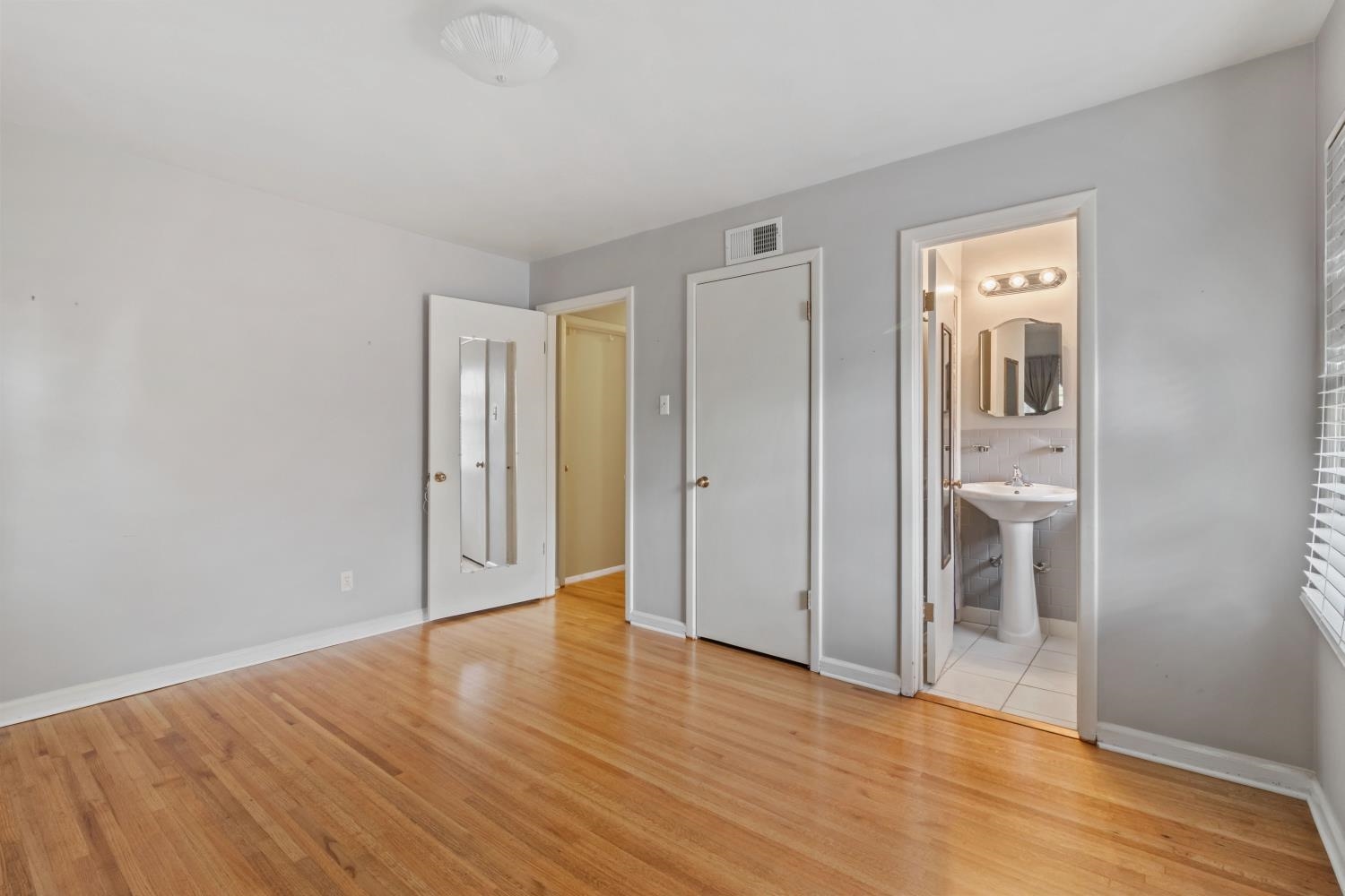 5034 Quince Road Memphis, TN 38117 - Photo 18 of 25 a view of an empty room with wooden floor and closet