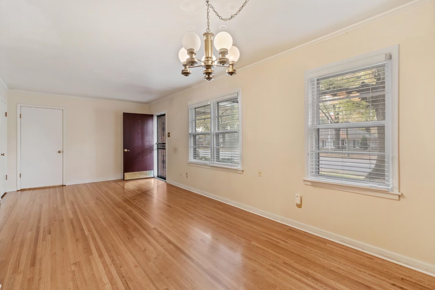 5034 Quince Road Memphis, TN 38117 - Photo 6 of 25 a view of an empty room with a window and wooden floor