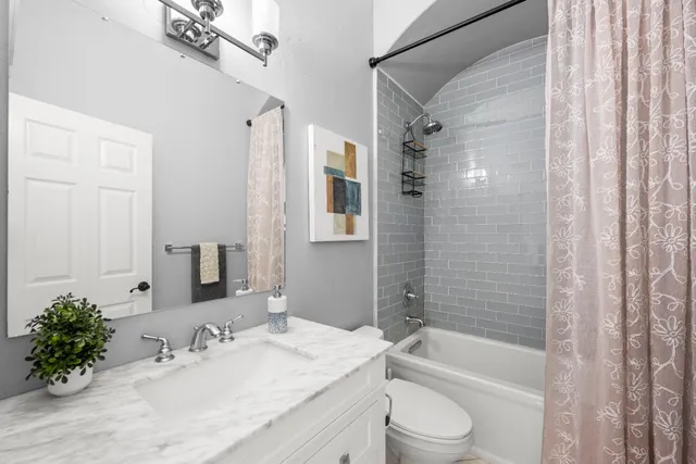 a large bathroom with a double vanity sink a large mirror and a bathtub