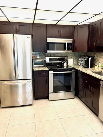 a kitchen with stainless steel appliances granite countertop a stove a refrigerator and a sink