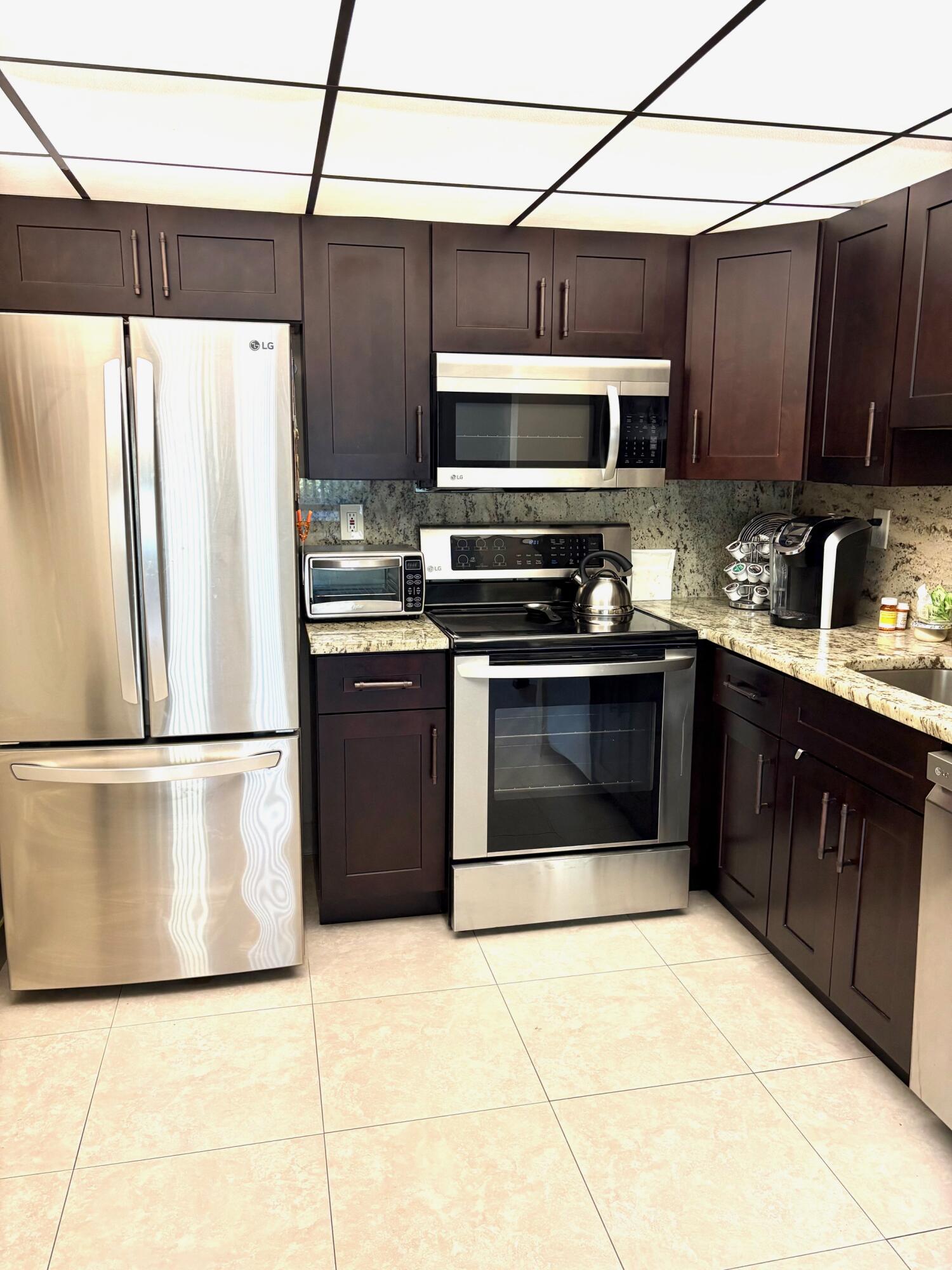 a kitchen with stainless steel appliances granite countertop a stove a refrigerator and a sink