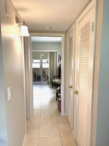 a view of a hallway with a livingroom and a bathroom