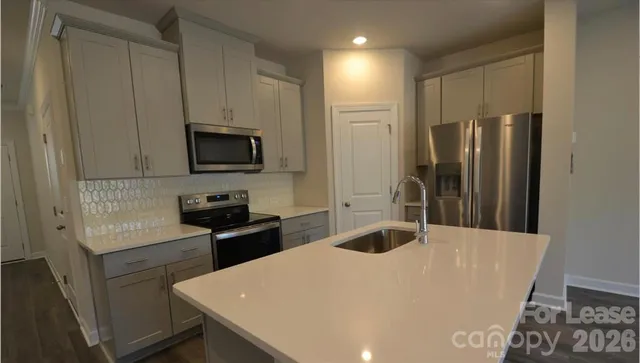 a kitchen with stainless steel appliances a refrigerator sink and stove