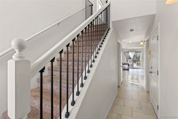 a view of staircase with lots of frames on wall and wooden floor