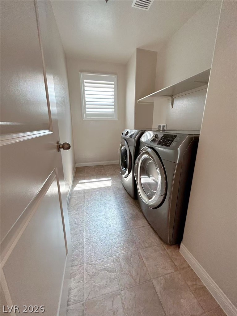 146 Tree Shot Court Las Vegas, NV 89113 - Photo 9 of 18 A well-appointed laundry area features modern appliances and convenient shelving.
