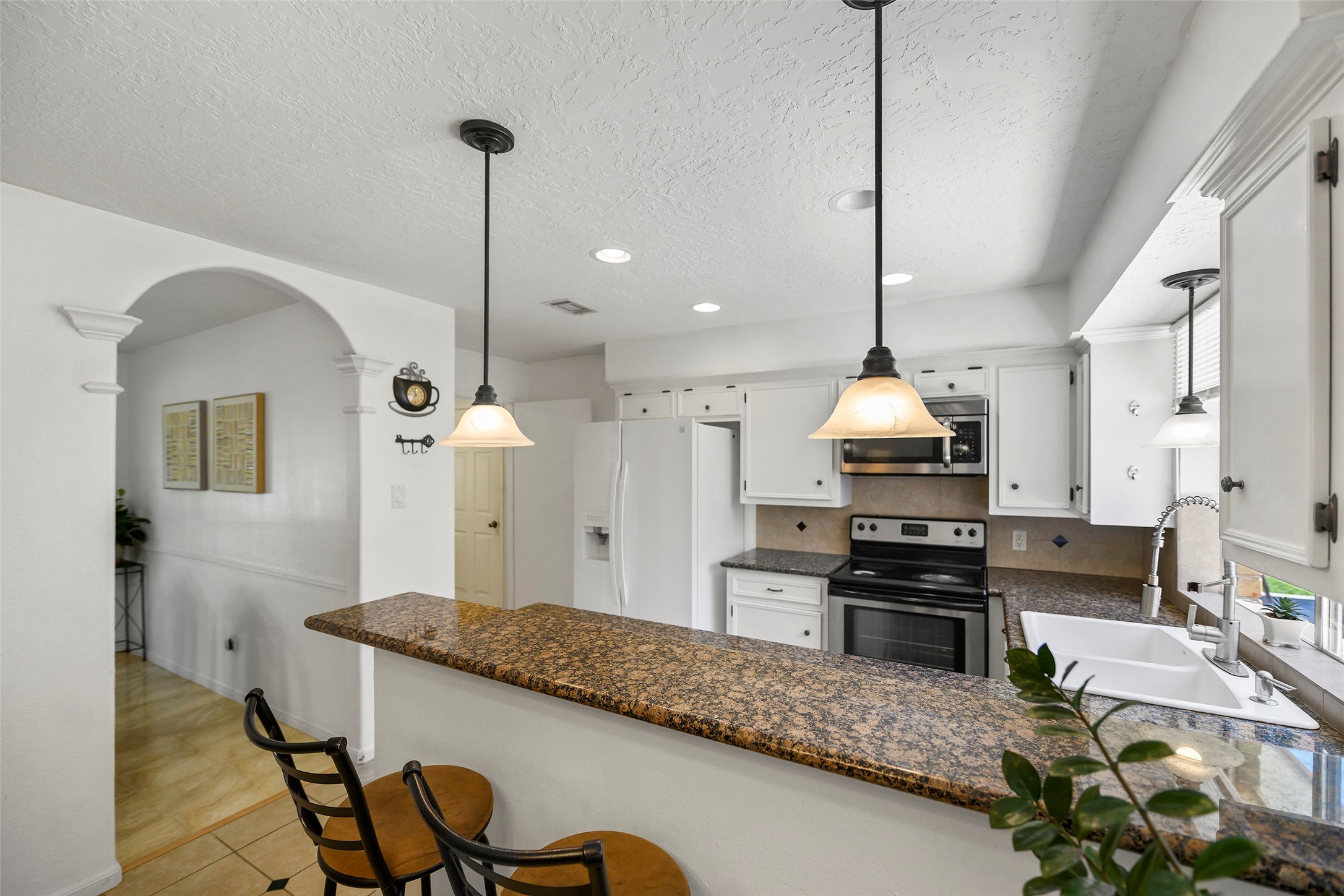6815 River Mill Drive Spring, TX 77379 - Photo 7 of 33 a kitchen with stainless steel appliances granite countertop a stove a sink and a refrigerator