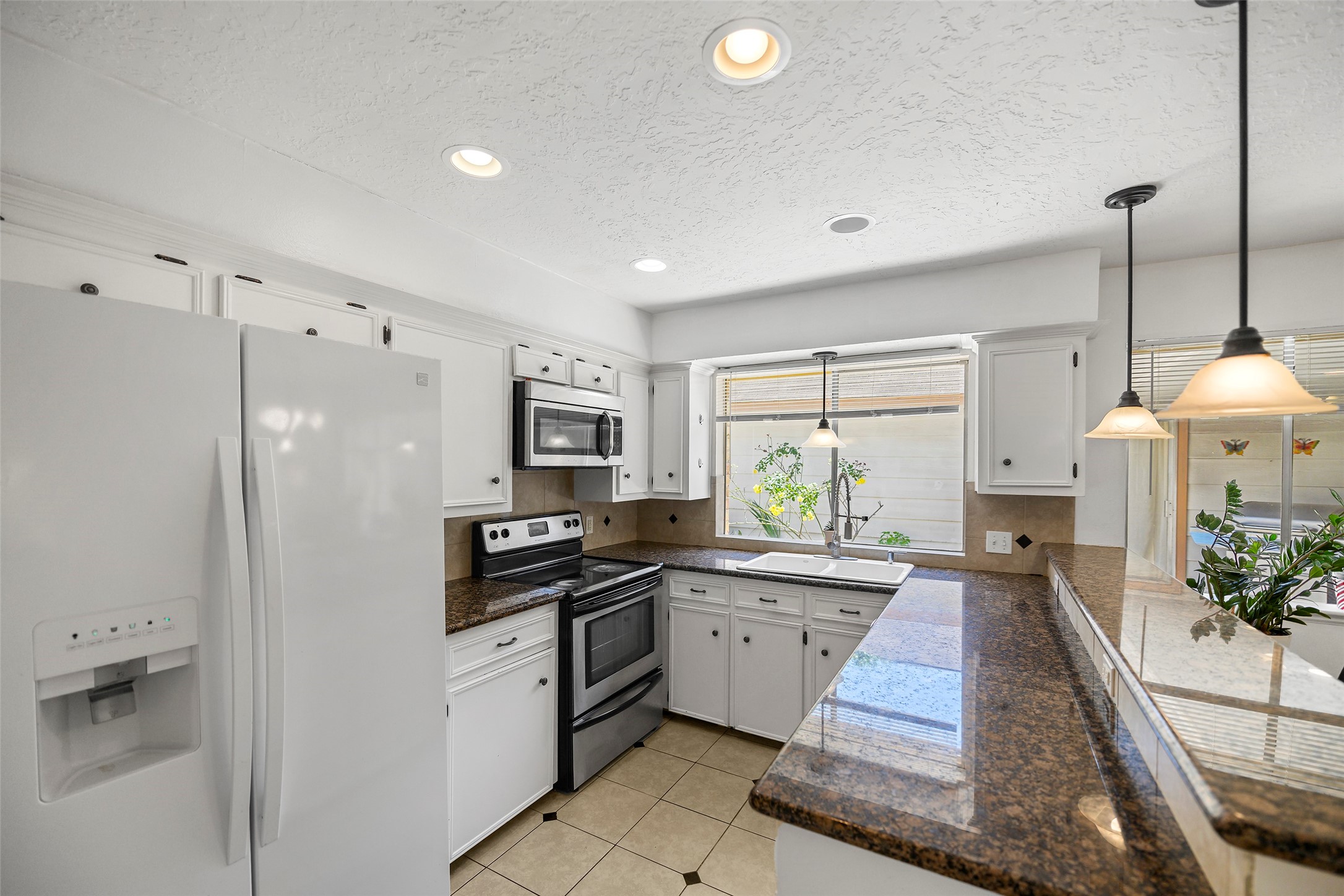 6815 River Mill Drive Spring, TX 77379 - Photo 9 of 33 a kitchen with granite countertop a sink a counter top space appliances and cabinets
