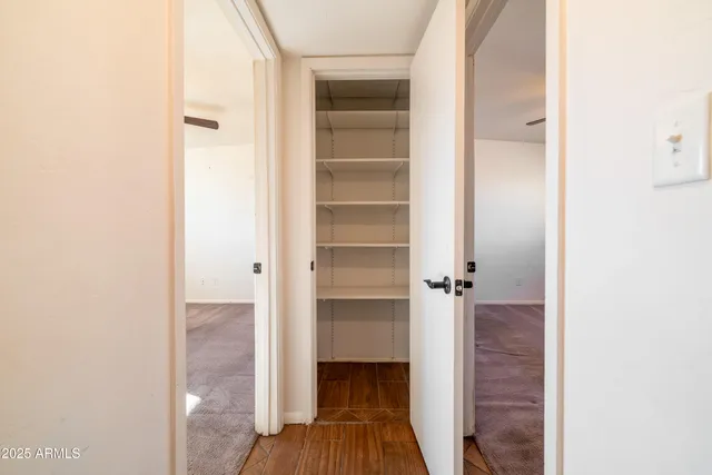 a view of a hallway with wooden floor and closet