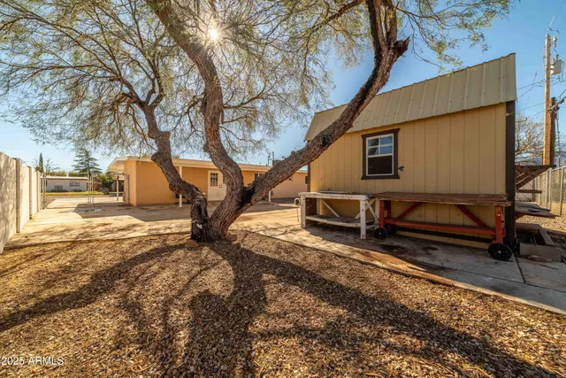 a backyard of a house with barbeque oven table and chairs