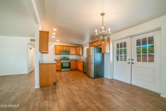 a view of a kitchen with refrigerator and windows