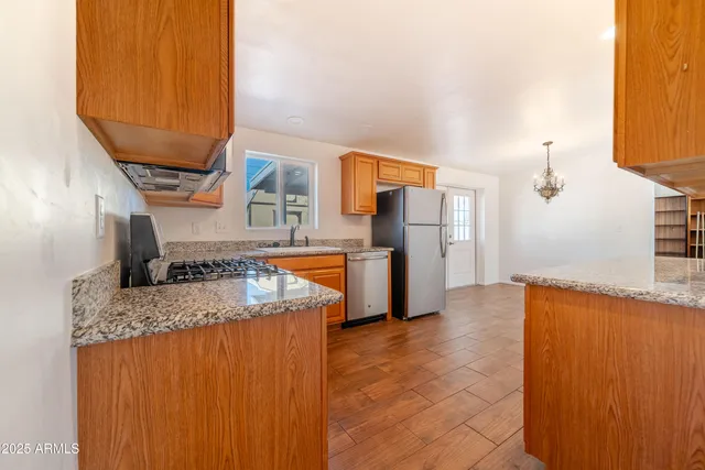 a kitchen with stainless steel appliances granite countertop a sink a stove and a refrigerator