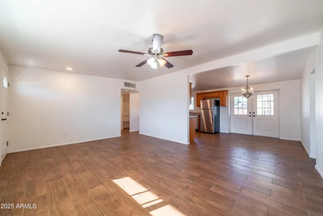 a view of an empty room with window and wooden floor
